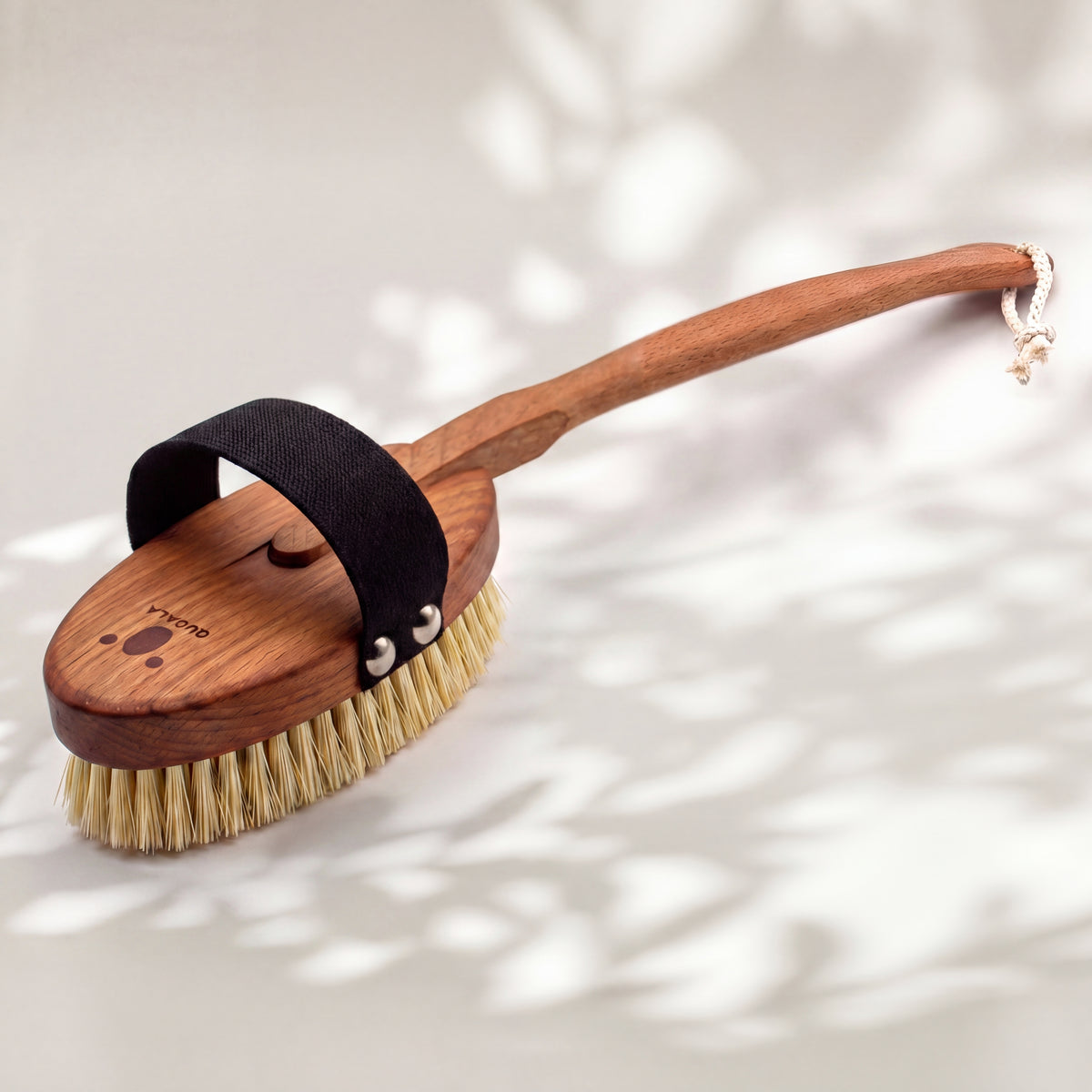 Rückseite der Badebürste mit QUOALA-Logo im Holz und geknoteter Aufhängekordel