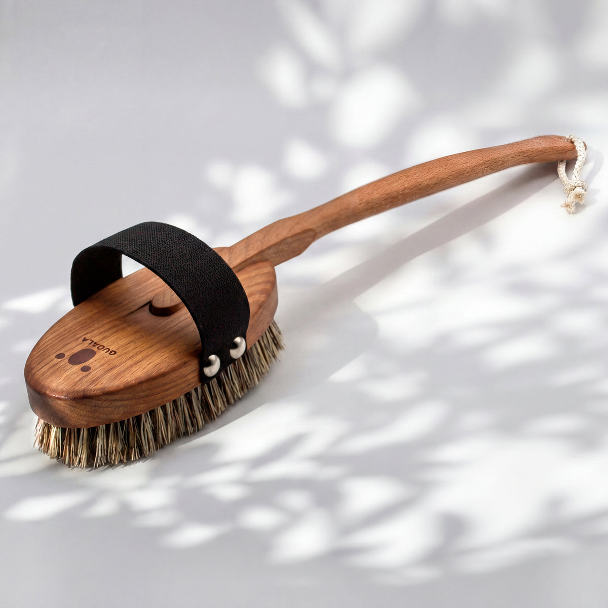 Rückseite der Badebürste mit QUOALA-Logo im Holz und geknoteter Aufhängekordel