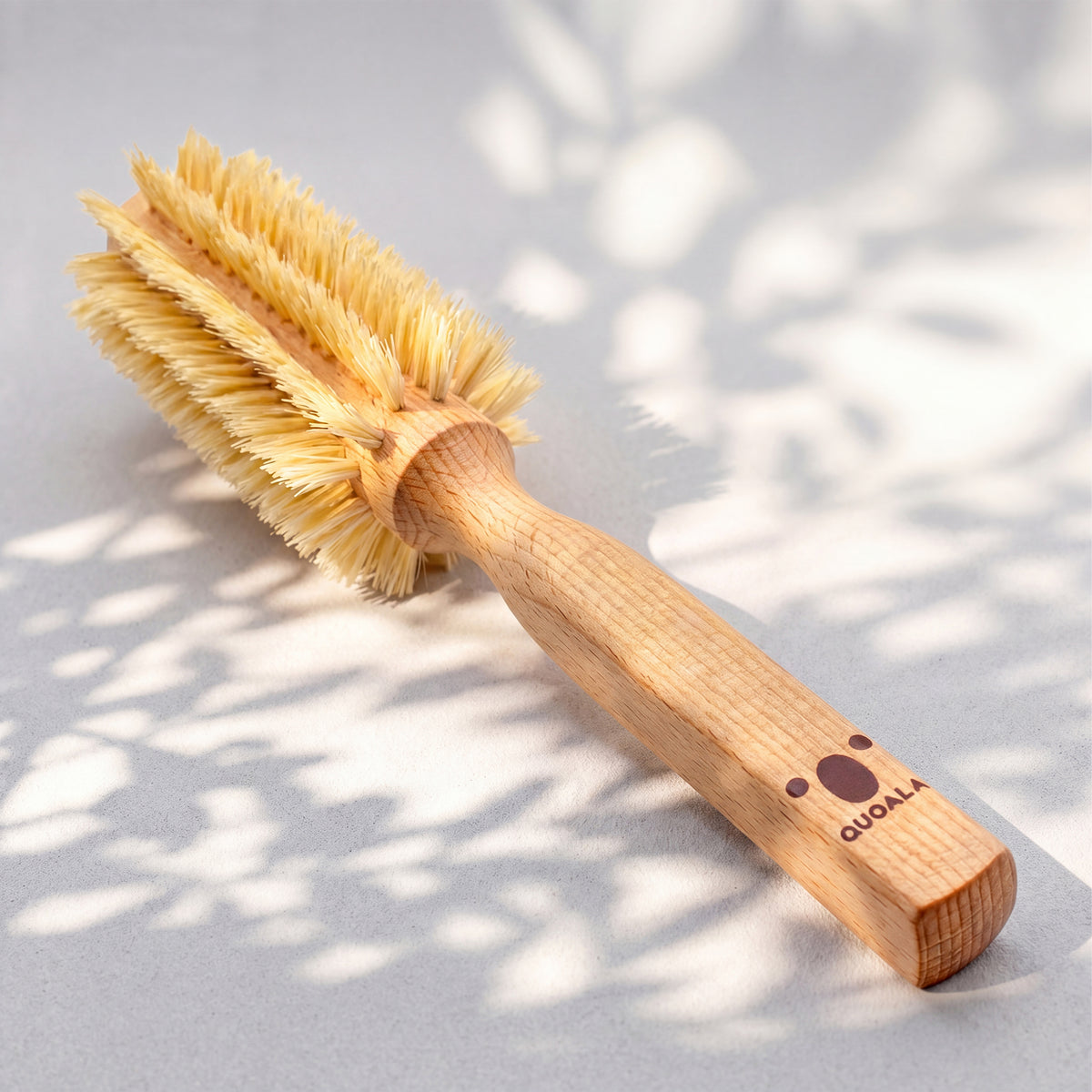 Föhnbürste in ganzer Länge, diagonal, mit kantigem Holzgriff und QUOALA-Logo